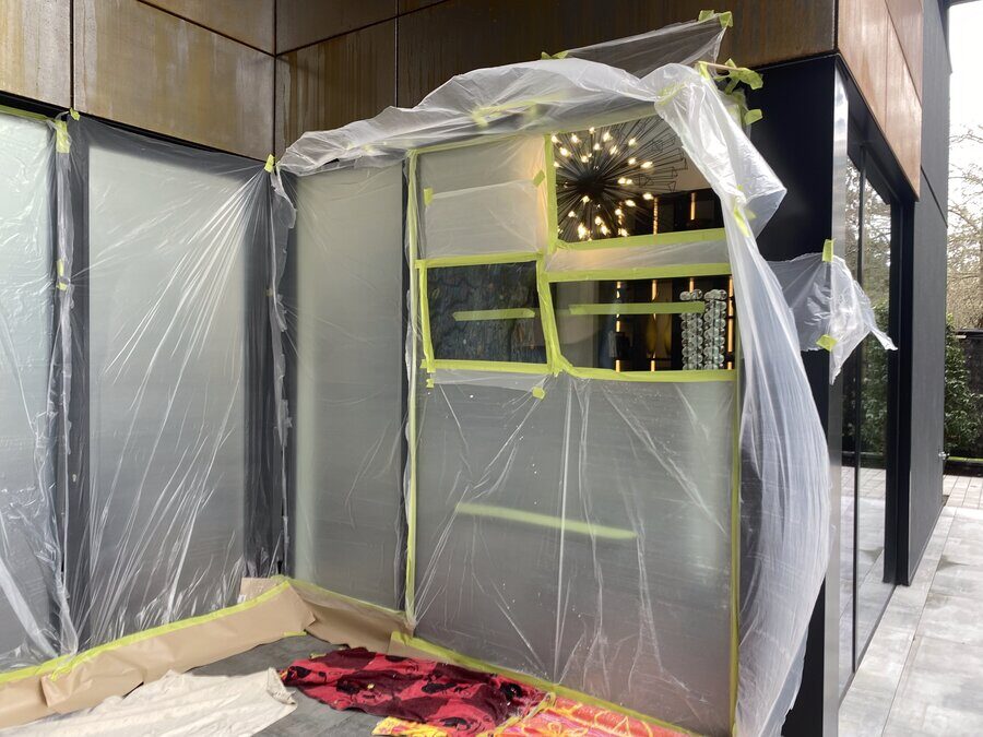 Wraparound windows sealed off with plastic sheeting before polishing